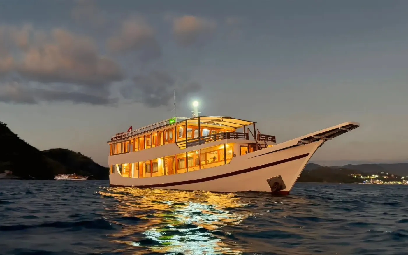 Ayvara Cruise lit up at anchor at dusk