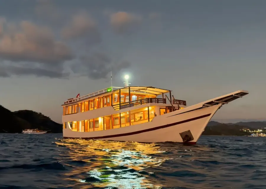 Ayvara Cruise lit up at anchor at dusk